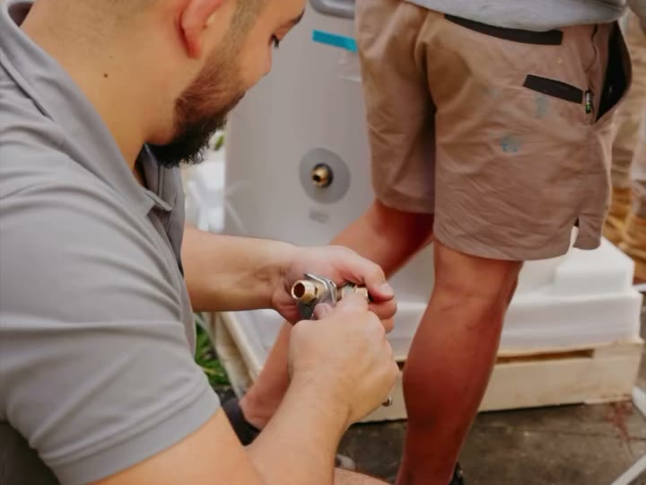Plumber fitting a new valve on a hot water system